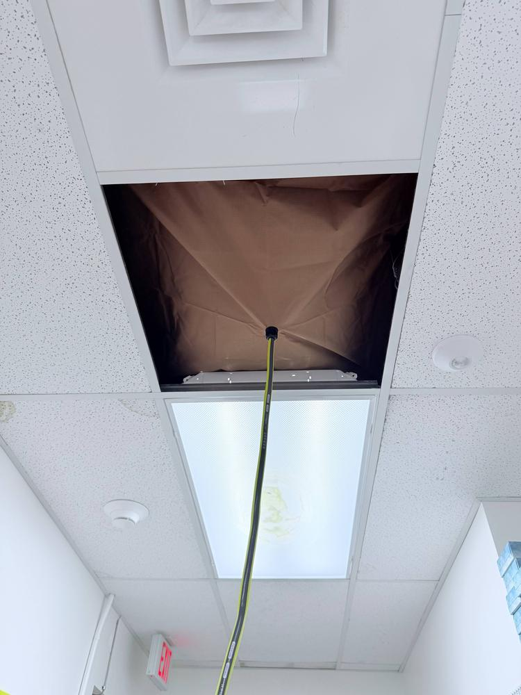 Ceiling tile removed for access to ductwork during commercial maintenance