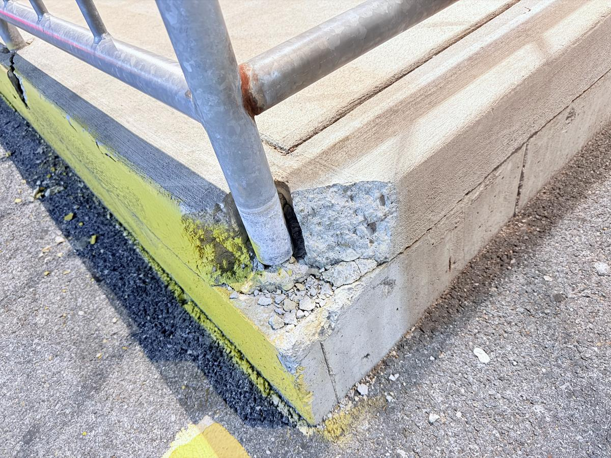 Damaged concrete curb and walkway edge before repair