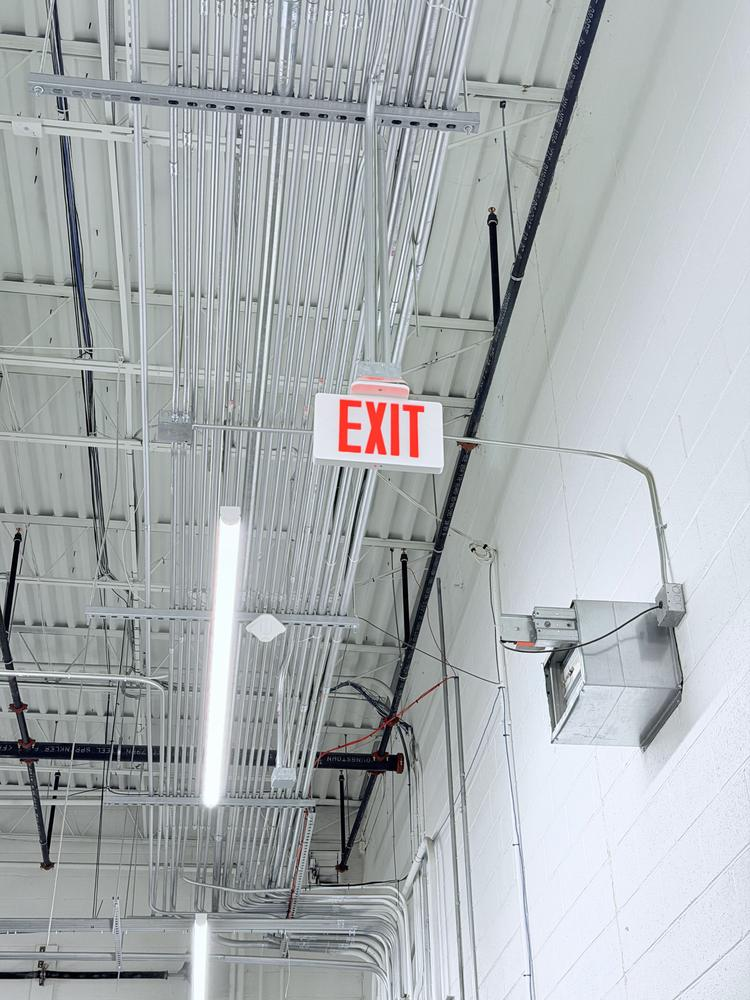 Illuminated exit sign installed in a commercial warehouse