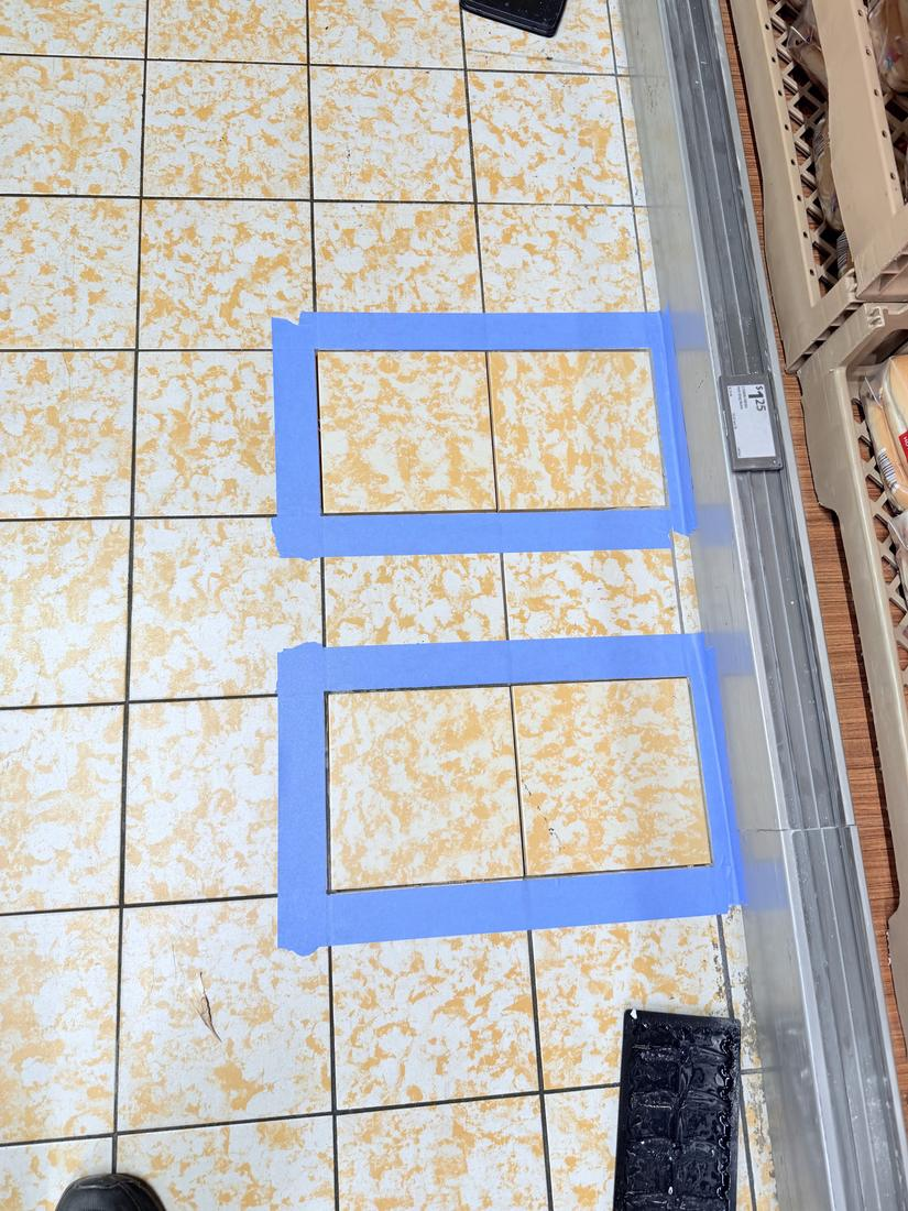 Damaged commercial floor tiles marked out for removal