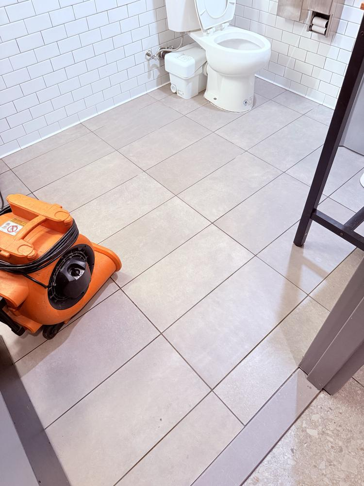 Floor scrubber in use during commercial restroom maintenance