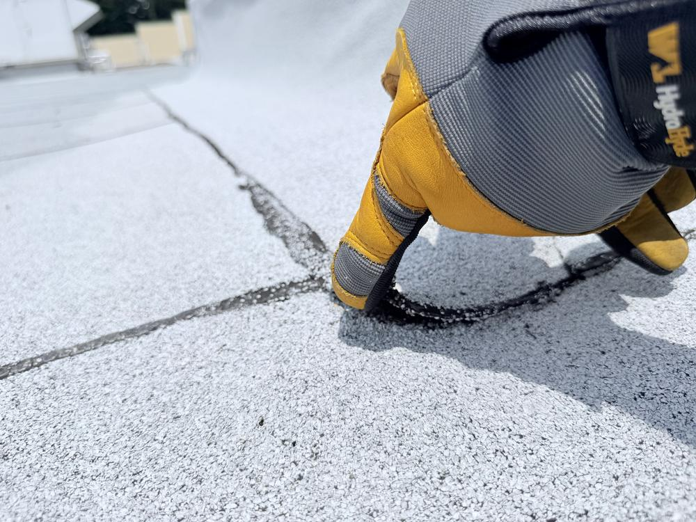 Inspecting and sealing a seam on a commercial flat roof