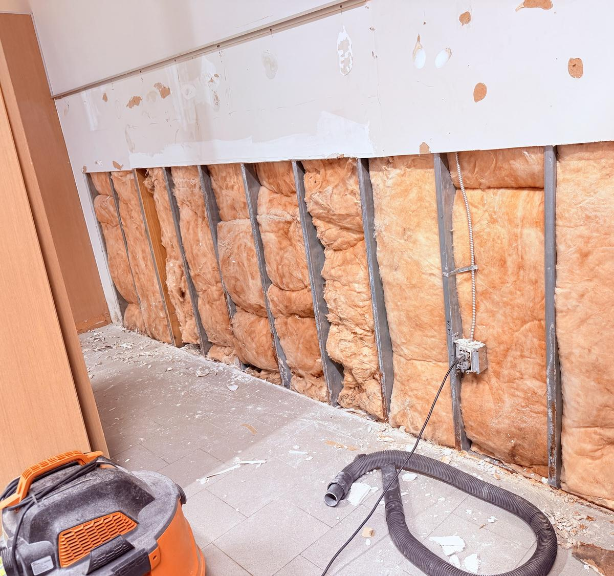 Water-damaged commercial wall opened to the studs before repair
