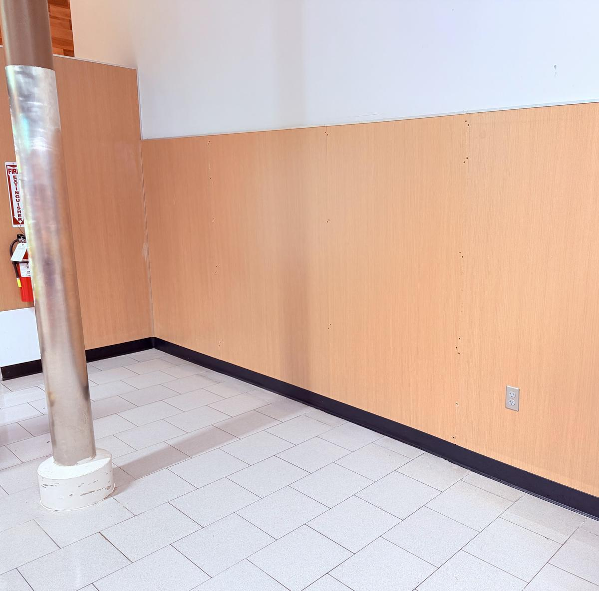 Repaired commercial wall refinished with new panel and base