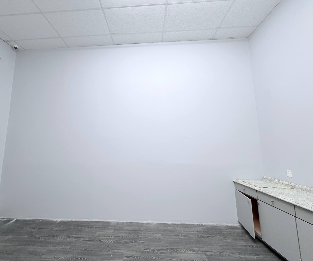 Finished commercial wall repair with new drywall, paint and flooring